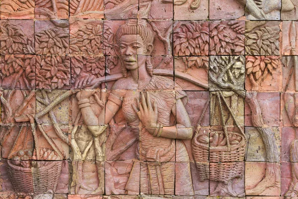 Women lifting fruit concrete carving — Stock Photo, Image