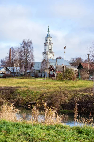 Kostel stojí na podzim u řeky — Stock fotografie