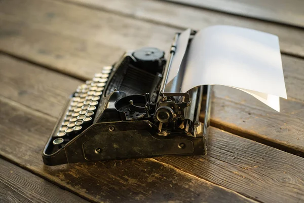 Una macchina da scrivere con un foglio di carta poggia sul tavolo — Foto Stock