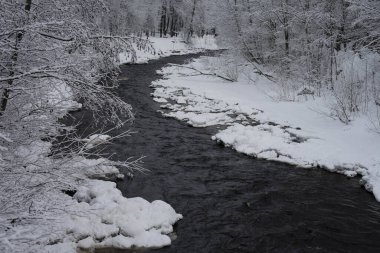 Kış parkında karanlık ve hızlı nehir