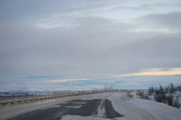 Amanecer en un camino de invierno con nubes — Foto de Stock
