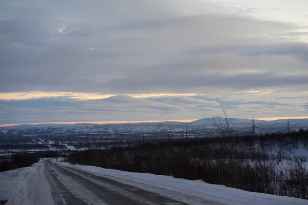 Amanecer en un camino de invierno con nubes — Foto de Stock