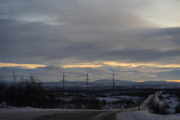 Alba su una strada invernale con nuvole — Foto Stock