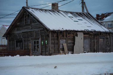 Eski yıkılmış ahşap evler karın üzerinde duruyor.