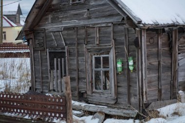 Eski yıkılmış ahşap evler karın üzerinde duruyor.
