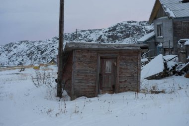 Eski yıkılmış ahşap evler karın üzerinde duruyor.