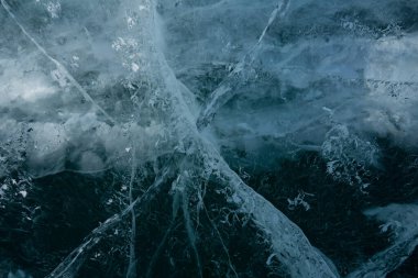 Gölde şeffaf buzda beyaz çatlaklar