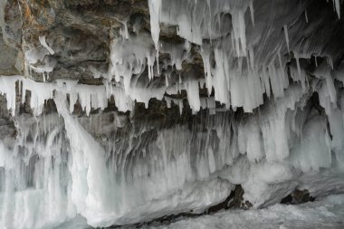 Buz ve kar kalıpları ve buz sarkıtları kayaların üzerinde ve kışın bir mağarada