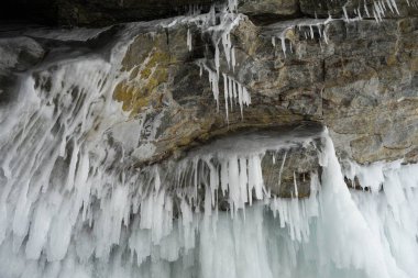 Buz ve kar kalıpları ve buz sarkıtları kayaların üzerinde ve kışın bir mağarada