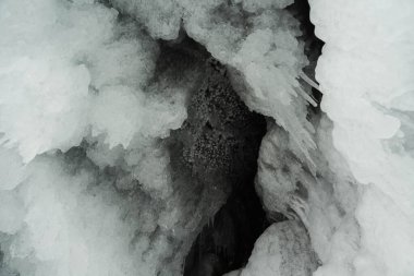 Buz ve kar kalıpları ve buz sarkıtları kayaların üzerinde ve kışın bir mağarada