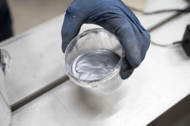 Bir adam mavi eldivenle boyayı yayar.