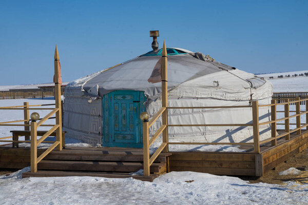 white yurt in the winter in the sun during the day