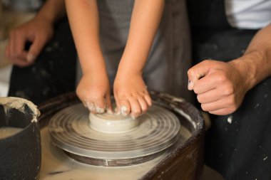 Çemberin üzerinde kilden bir ürün yapan eller