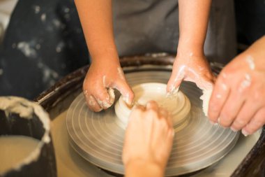 Çemberin üzerinde kilden bir ürün yapan eller