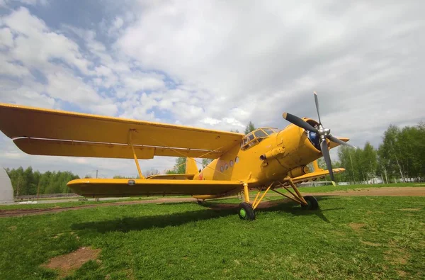 Avião amarelo em um contexto de céu e grama — Fotografia de Stock