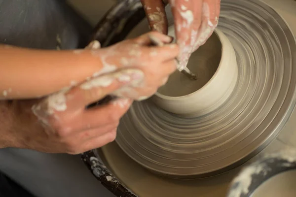 Человеческие руки делают глиняный продукт на гончарных колесах — стоковое фото