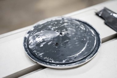 Siyah boyalı beyaz plastik kavanoz.