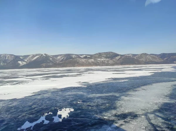 Kışın Kar Kaplı Dağların Arasında Gölün Şeffaf Mavi Buzu — Stok fotoğraf