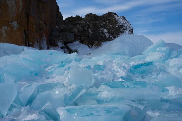 Rotsen met ijs en ijspegels in de buurt van het meer — Stockfoto