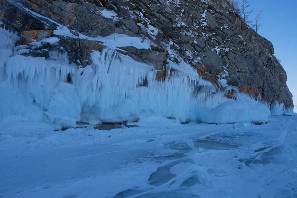 Rochers avec des chevauchements de glace et des glaçons près du lac — Photo