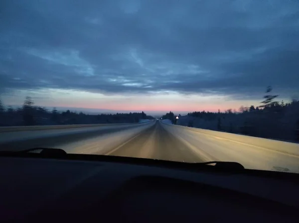 Winterweg bij zonsondergang met felrode zon — Stockfoto