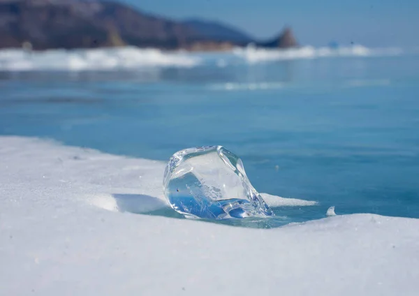 Transparent ice floes lie on the transparent ice of the lake — Stock Photo, Image