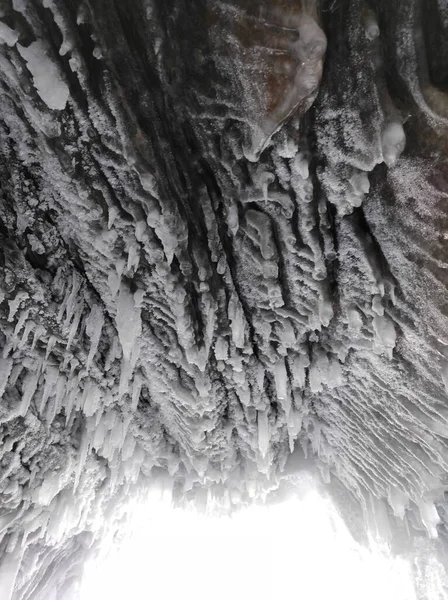 Jaskinia lodowa z długimi soplami lodu i pokrywającymi się — Zdjęcie stockowe