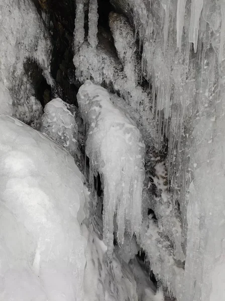 洞穴中岩石上的积雪冰柱和透明的冬季图案 — 图库照片