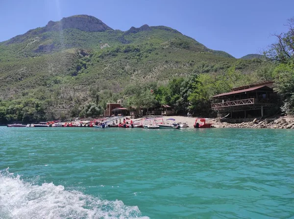 Mavi nehri olan derin bir kanyon ve mavi gökyüzüne karşı güzel dağlar.