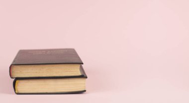 Pembe arka planda bir yığın kapalı kitap.