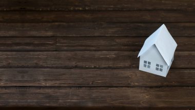 Minyatür ev. Ahşap bir arka planda. Evin yerleşimi. Kavramsal