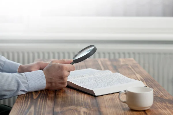 Libro Biblia Abierto Lupa Mano Una Mesa Madera Concepto Investigación — Foto de Stock