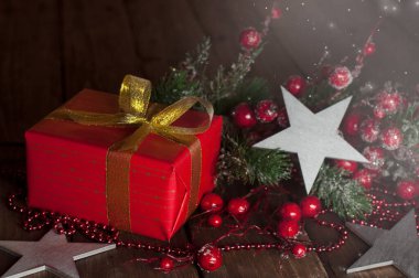 Kırmızı pakette hediye. Noel ve Yeni Yıl. Selamlama ve paket bandı. Sevgililer Günü. Ahşap bir arka planda.