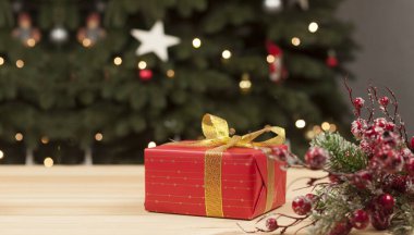 Kırmızı pakette hediye. Noel ve Yeni Yıl. Ahşap bir arka planda