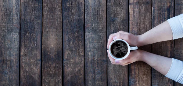 少女の手にティーコーヒーを一杯 木製のテーブルの上 朝のコンセプト — ストック写真