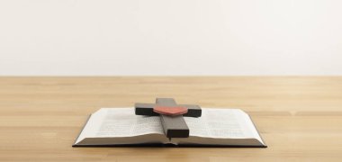 Ahşap bir masanın üzerinde İncil 'i aç. İsa 'nın haçı ahşaptır. Süvariler