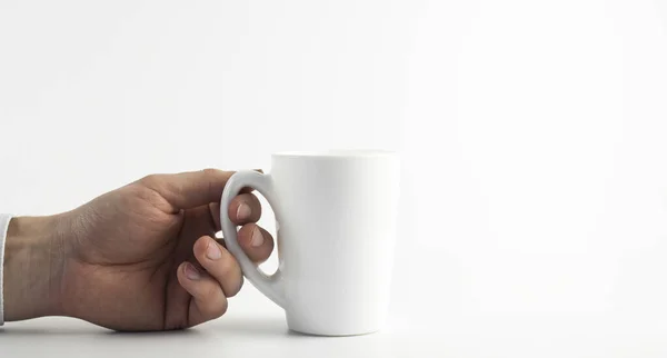 White cup in hand on a white background. Businessman hand.