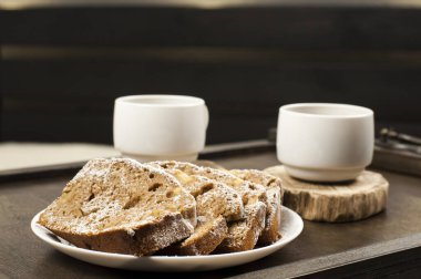 Tahta bir tepside iki beyaz fincan kahve. Yatakta kahvaltı.