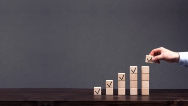 Tahta küpler yükselme sırasına göre dizilmiştir. En üst küpü iş adamının eli koyar. Kâr, finansal büyüme konsepti. İlerleme