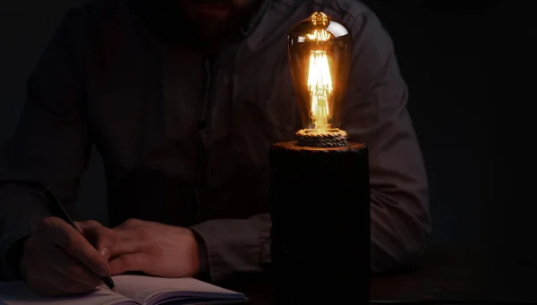 Чоловік Пише Блокноті Лампа Столі Темряві — стокове фото