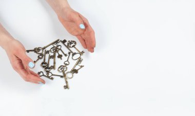 Manikür. Turkuaz manikürlü kadın elleri. Eski anahtar elinde. Sevgi. Beyaz arkaplanda.