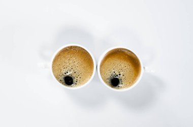 Köpüklü iki beyaz kahve. Beyaz arka planda. Kahvaltı..