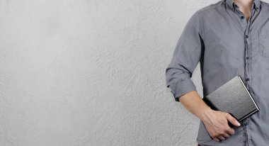 Elinde kitap olan gömlekli genç bir adam. İşadamı.