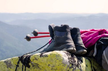 Seyahat botları. Trekking sopalarını dağların arka planına yaslıyor. Koşun!.