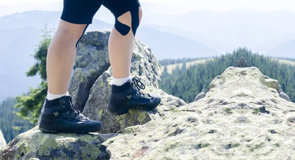 ハイキングブーツの観光客の足 トレッキングシューズ 山や岩を背景に — ストック写真