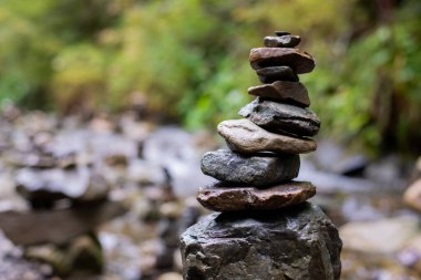 Doğada bir nehrin ortasında taş piramidi. Barışın ve dengenin sembolü. Karpatlar.