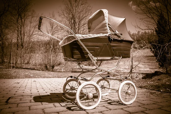 Kinderwagen im Retro-Stil im Freien an sonnigen Tagen, Sepia-Filter — Stockfoto