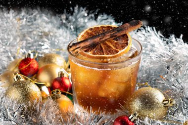Noel süslemeleri ile birlikte buzlu bir bardakta servis edilen özel Noel kokteyli.