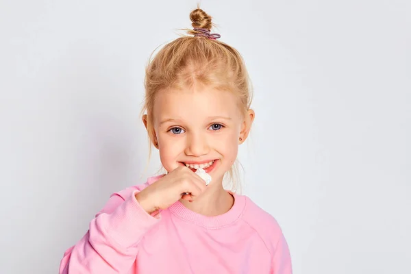 かわいい女の子は灰色の背景においしいヨーグルトを食べる ピンクのスウェットシャツに身を包んだ4 5歳の子供 テキストのスペース — ストック写真