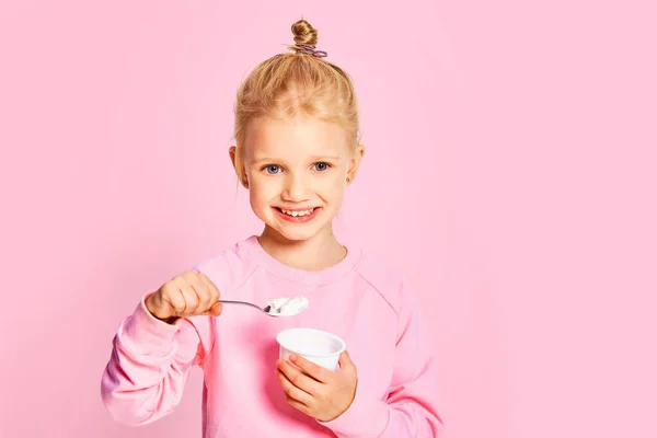 Menina Bonito Comer Iogurte Saboroso Fundo Rosa Criança Anos Posando — Fotografia de Stock